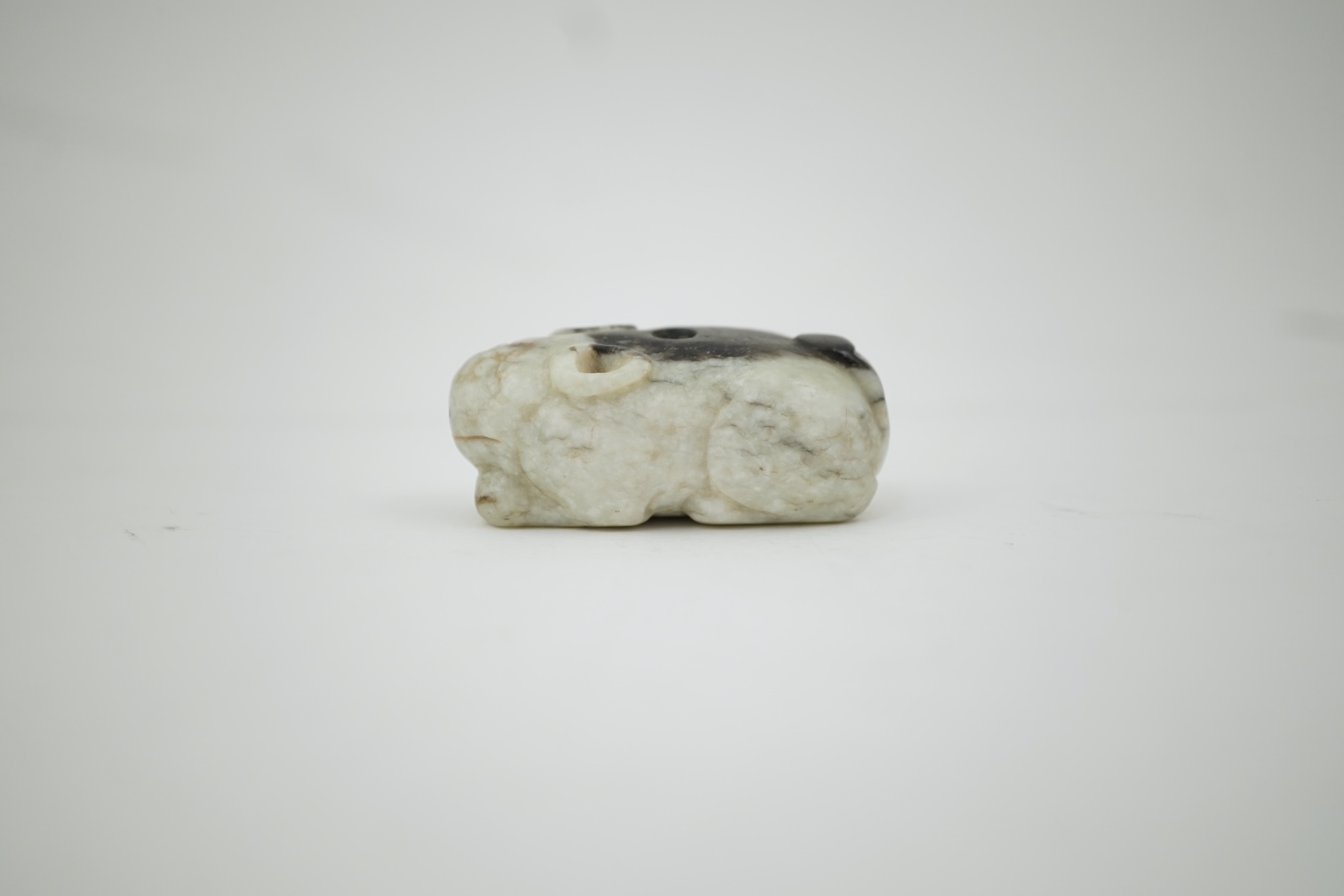 A Chinese white and black jade figure of a recumbent tiger, Song dynasty